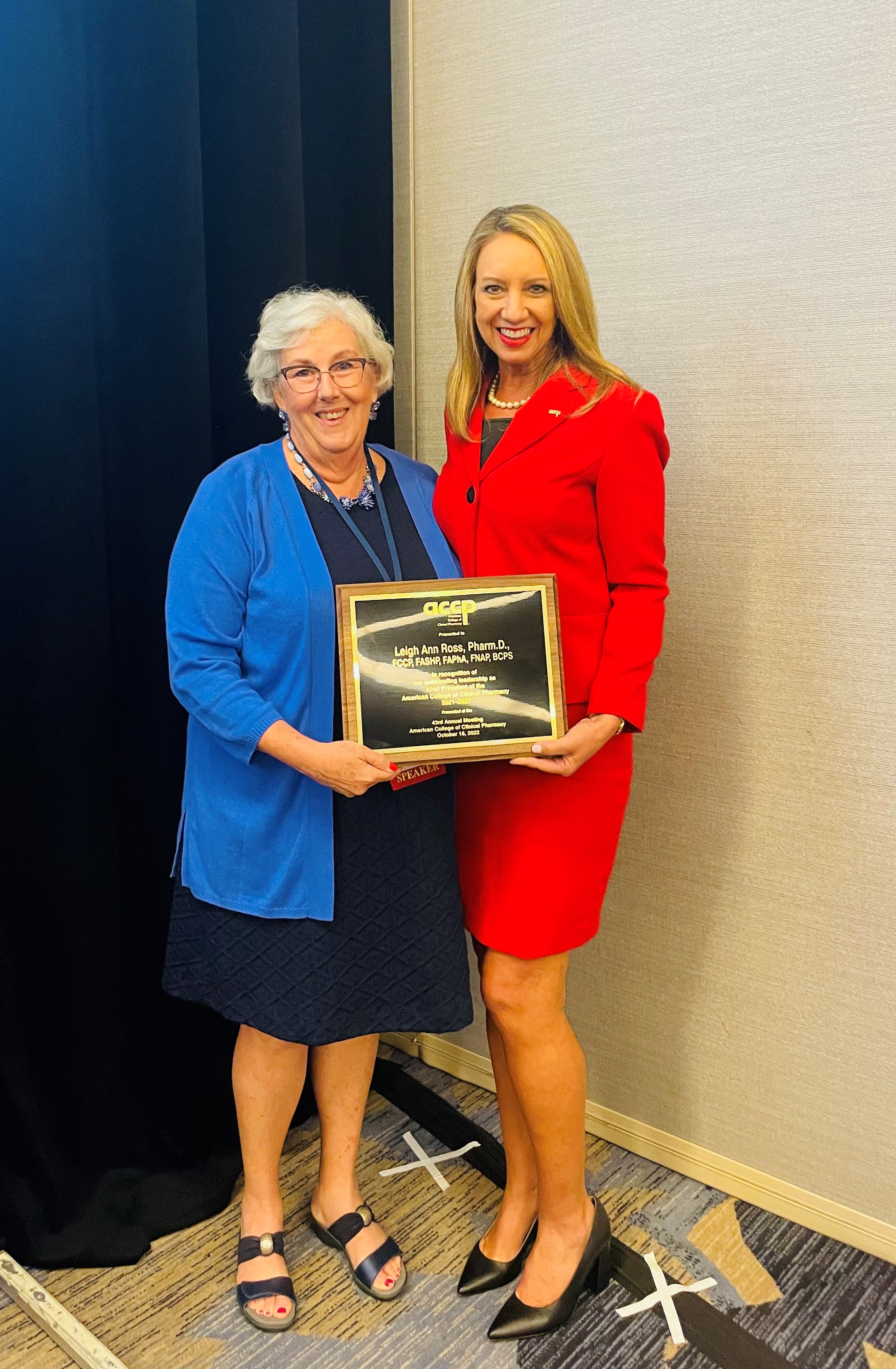 Incoming ACCP president  Elizabeth Farrington presents a plaque to outgoing ACCP president Leigh Ann Ross. 